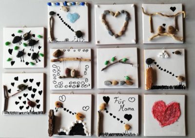 Von Kindern gebstelte Bilder mit Steinen und Zeichnungen.