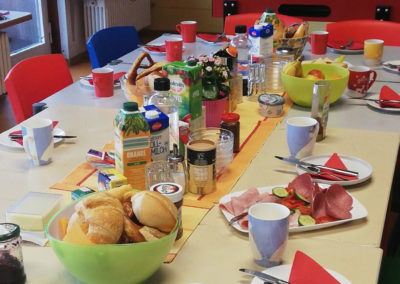 Ein mit Brötchen, Aufstrichen und Obst und gedeckter Tisch